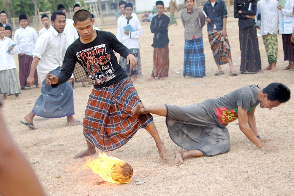 ***EXCLUSIVE*** KEDIRI, INDONESIA - OCTOBER 7: Students play Fire Football at the boarding school Lirboyo on October 7, 2012 in Kediri, Indonesia. THE PREMIER League boasts some of the hottest stars in the world – but they’ve got nothing on these fiery